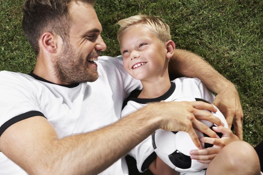 A picture of a parent and child holding a football